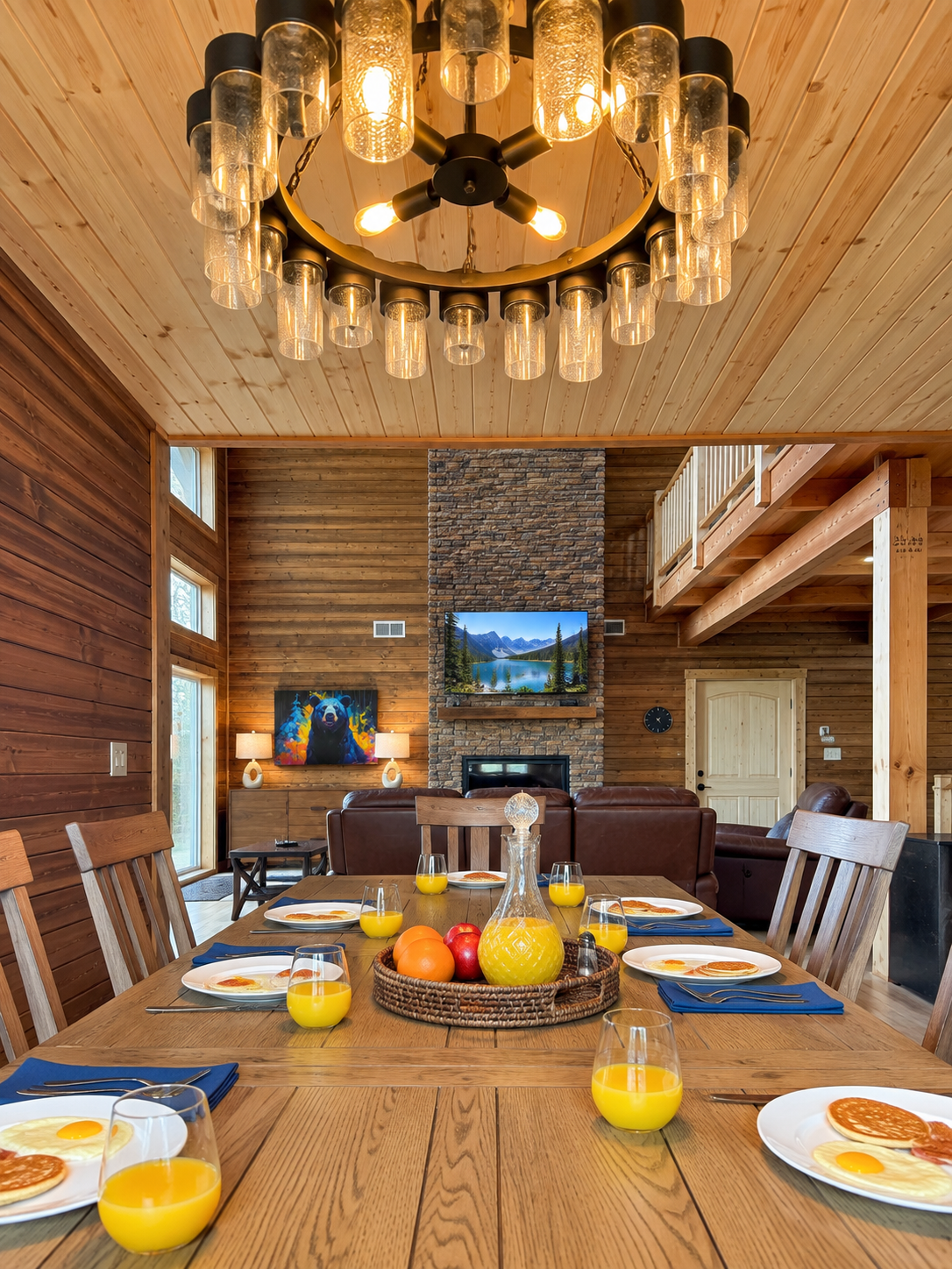Breakfast together · Gather around the wooden dining table, with warm lighting overhead and the living room just beyond.