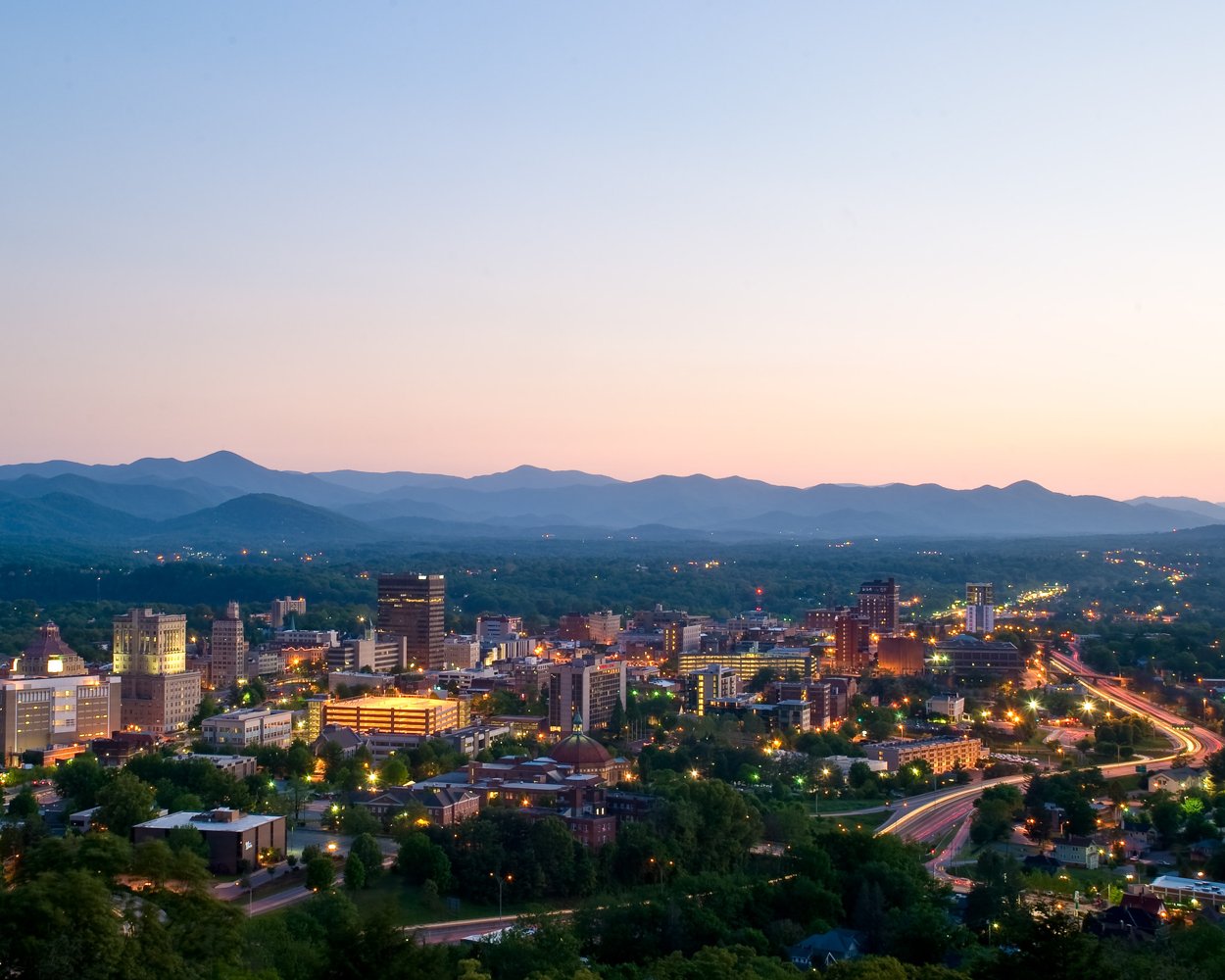 Asheville skyline at dusk beneath the Blue Ridge Mountains