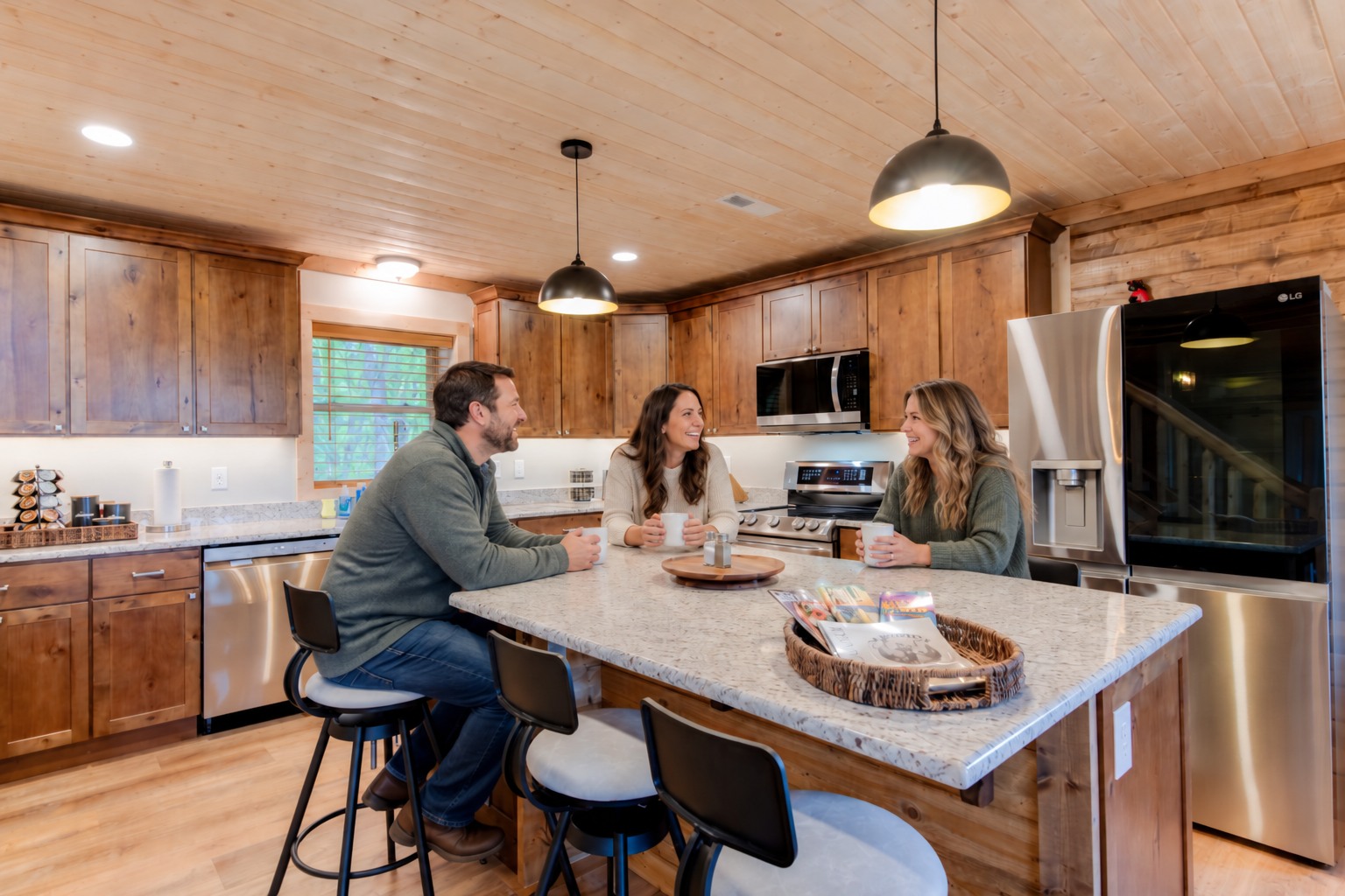 Three guests enjoying coffee around the kitchen island at Elk Mountain Escape