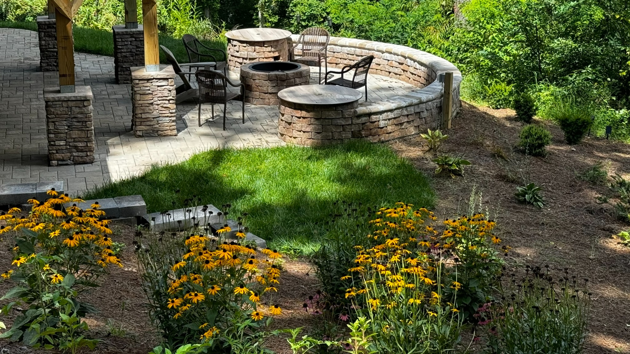 Patio and garden · Flowering garden beds border the stone patio, with seating for time outdoors.