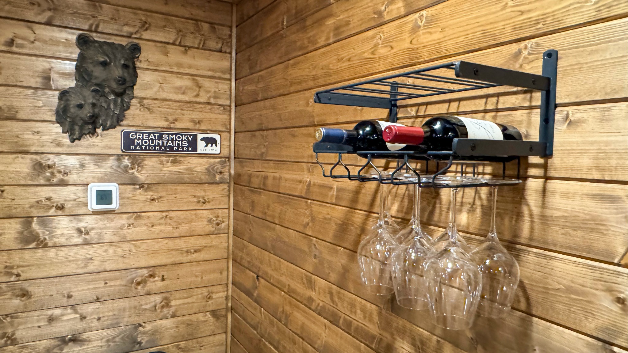 Vintage bar in the rec room · Wine storage and hanging glassware bring a welcoming touch to the bar and recreation room.